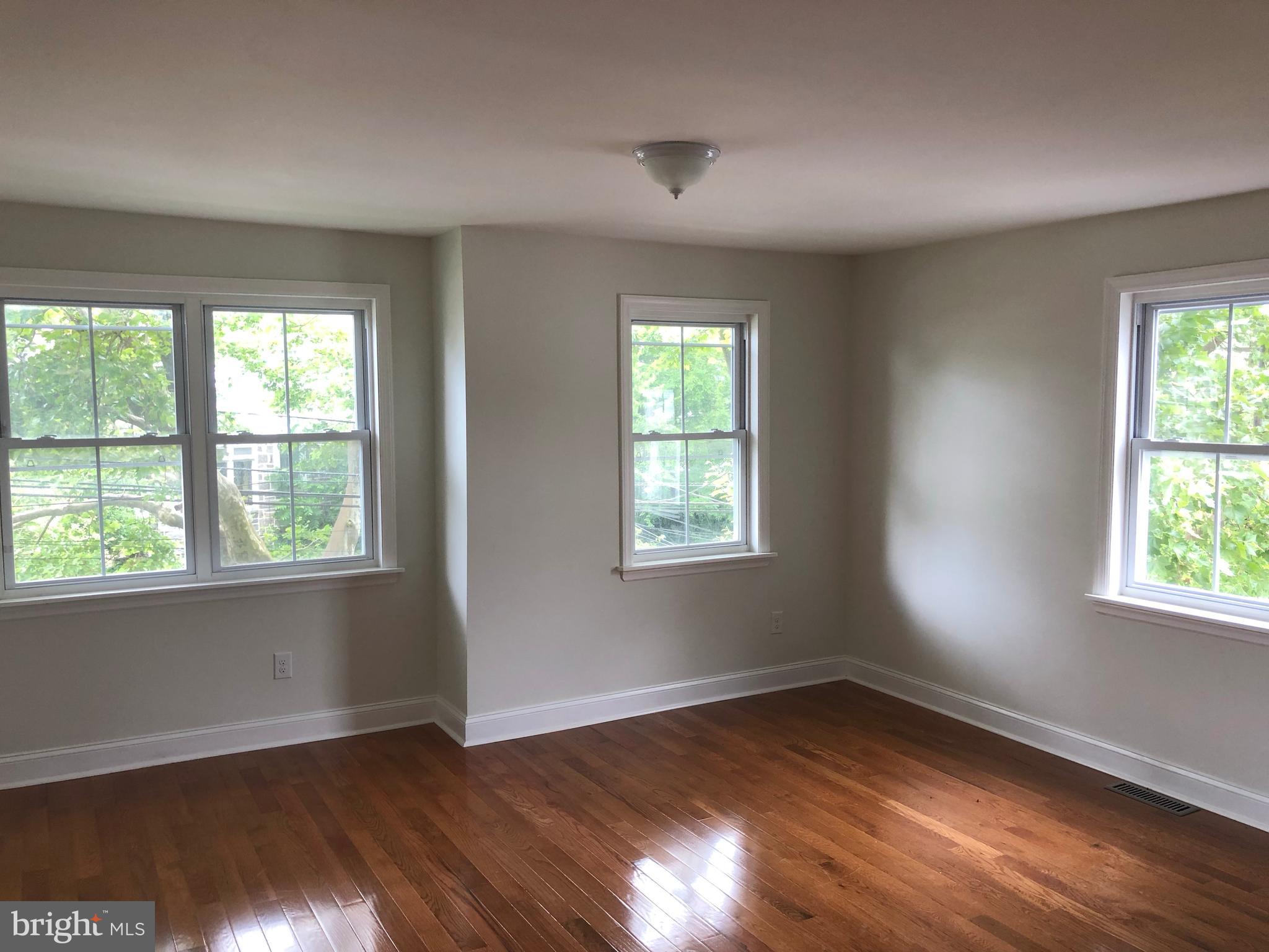 7703 Parkview Road Upper Darby, PA 19082 - Photo 20 of 30 a view of an empty room with wooden floor and a window