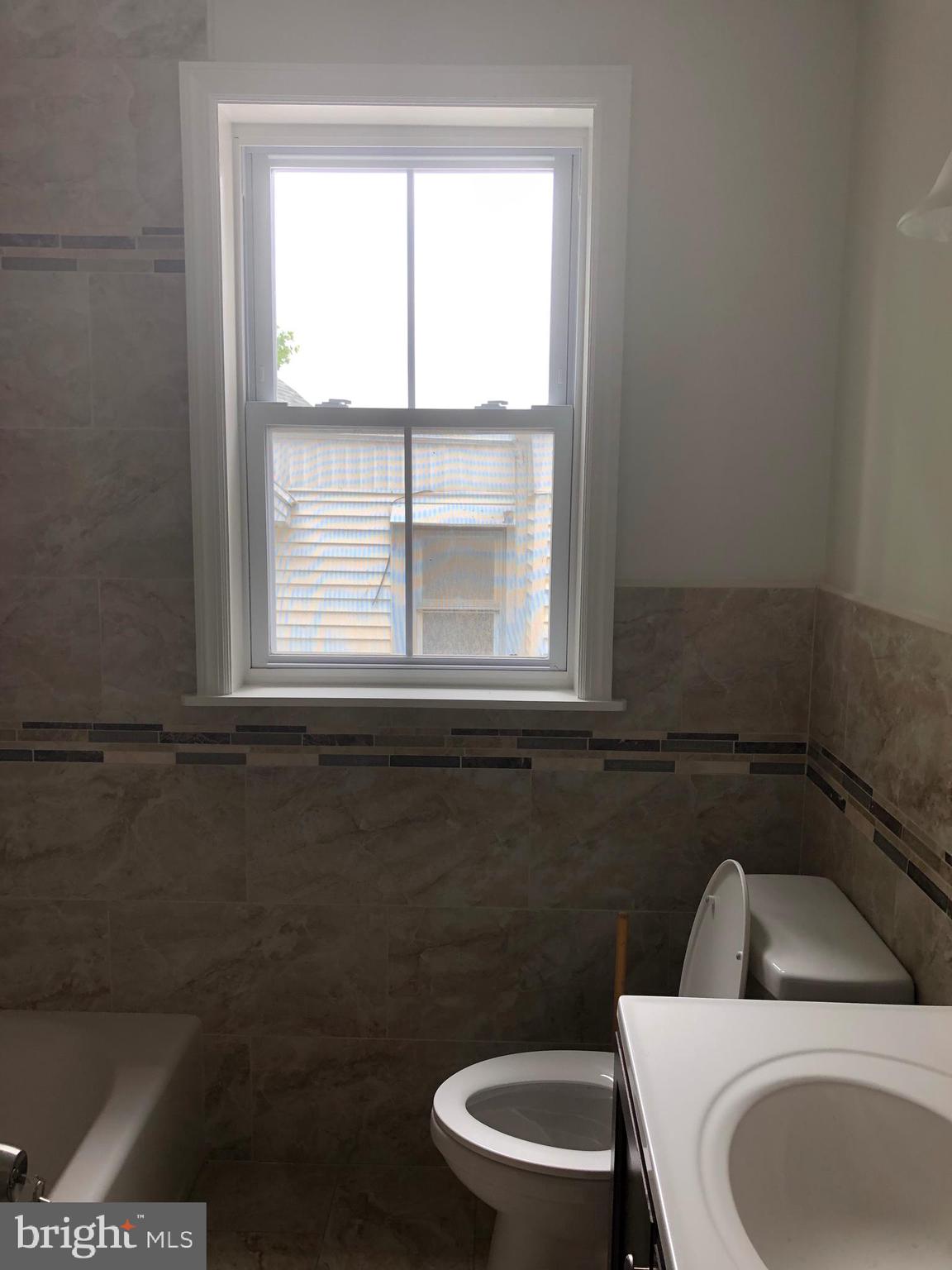 7703 Parkview Road Upper Darby, PA 19082 - Photo 23 of 30 a bathroom with a toilet a sink and a window