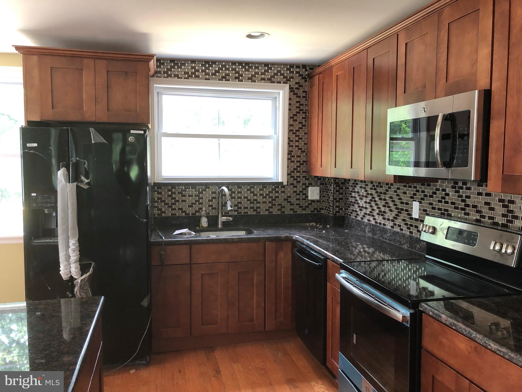 7703 Parkview Road Upper Darby, PA 19082 - Photo 6 of 30 a kitchen with granite countertop a sink stove and refrigerator