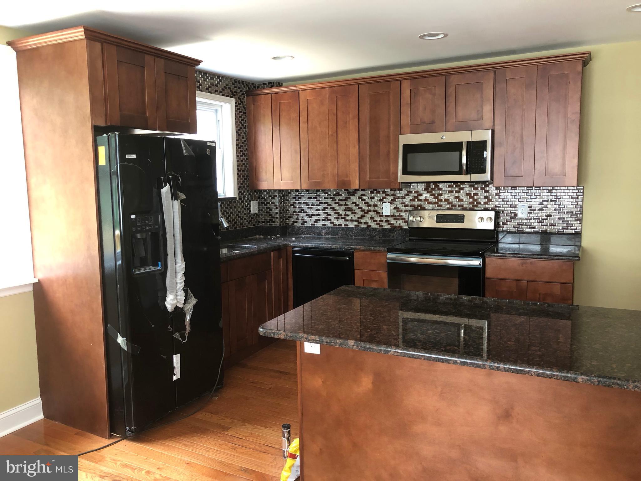7703 Parkview Road Upper Darby, PA 19082 - Photo 8 of 30 a kitchen with stainless steel appliances granite countertop a refrigerator stove and microwave