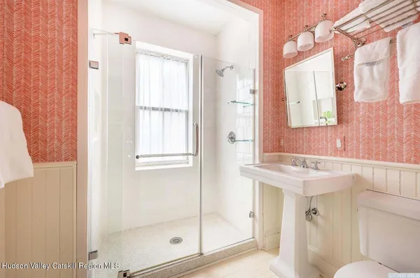 a bathroom with a shower a mirror and a sink