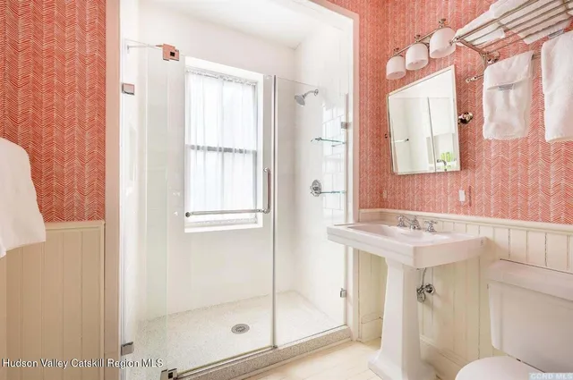 a bathroom with a shower a mirror and a sink