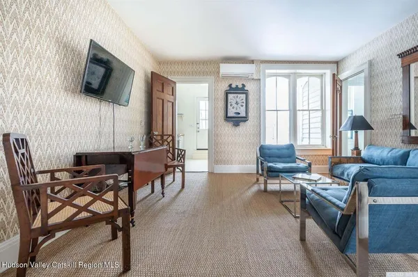 a living room with furniture a flat screen tv and a window