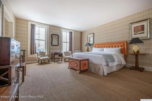 a spacious bedroom with a bed couch and a window