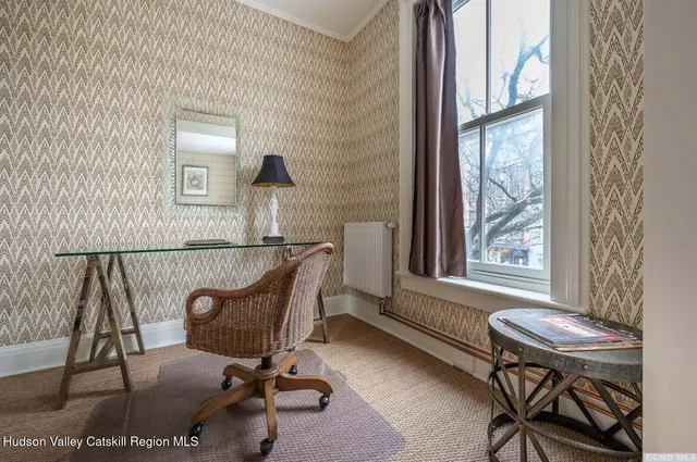 a view of a workspace with furniture and a window