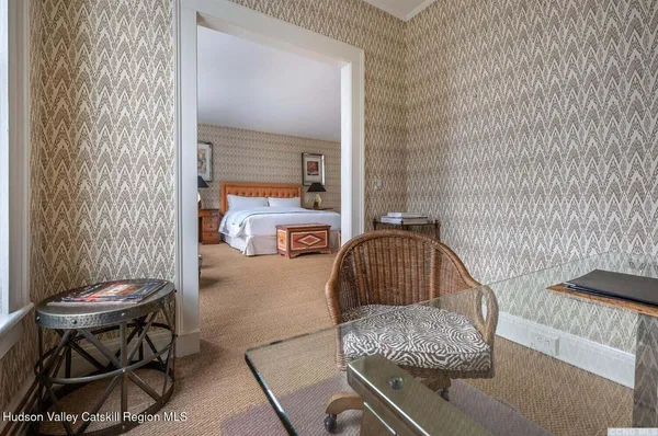 a bedroom with a bed a chair and a potted plant
