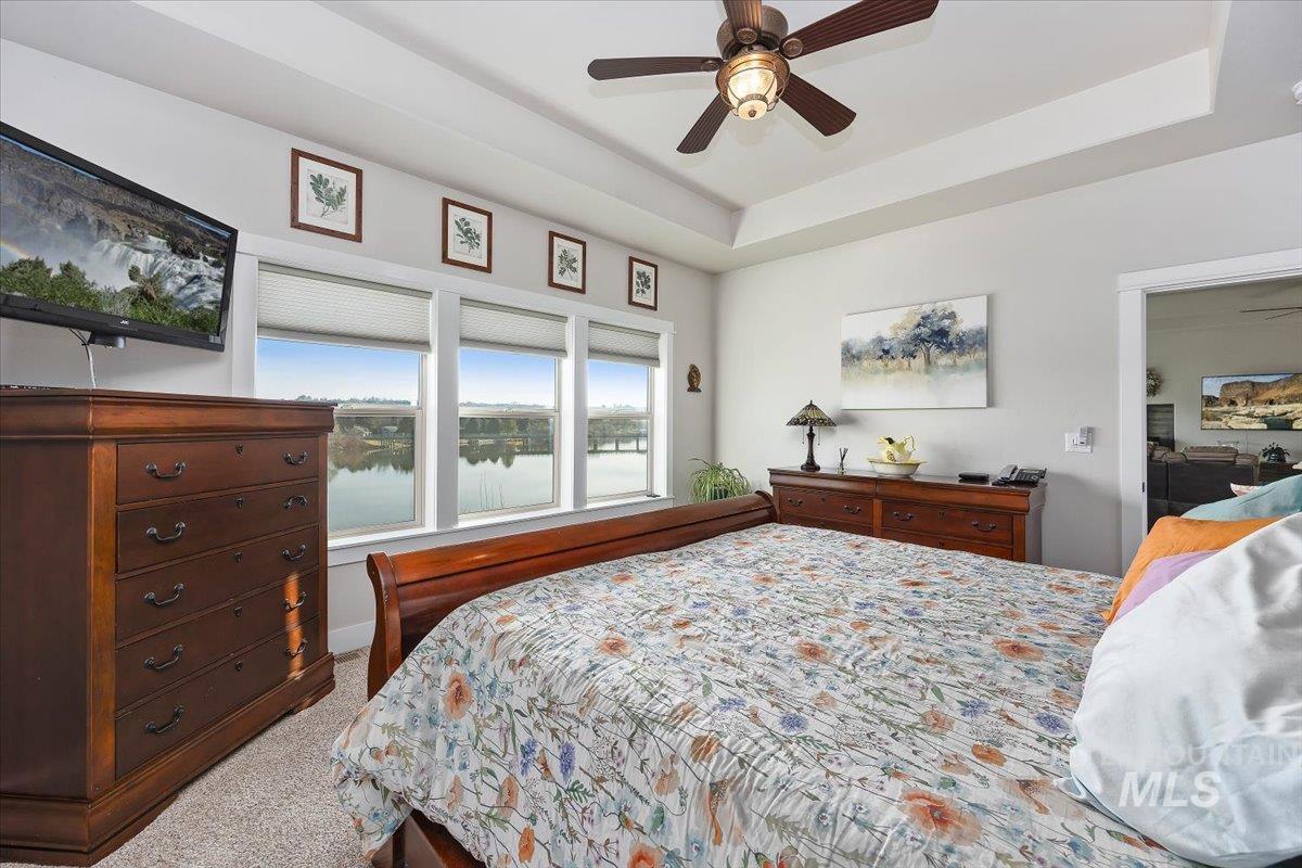 40 Bell Rapids Road Hagerman, ID 83332 - Photo 21 of 50 Bedroom with dark colored carpet, a tray ceiling, and a ceiling fan