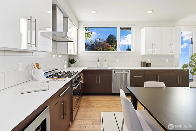 a kitchen with stainless steel appliances a sink a stove top oven a counter space and cabinets