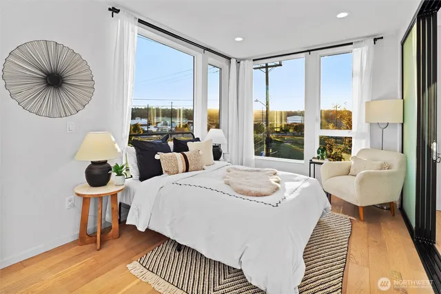 a bedroom with a bed and a large window