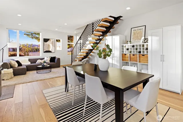 a kitchen with stainless steel appliances a dining table chairs and a refrigerator