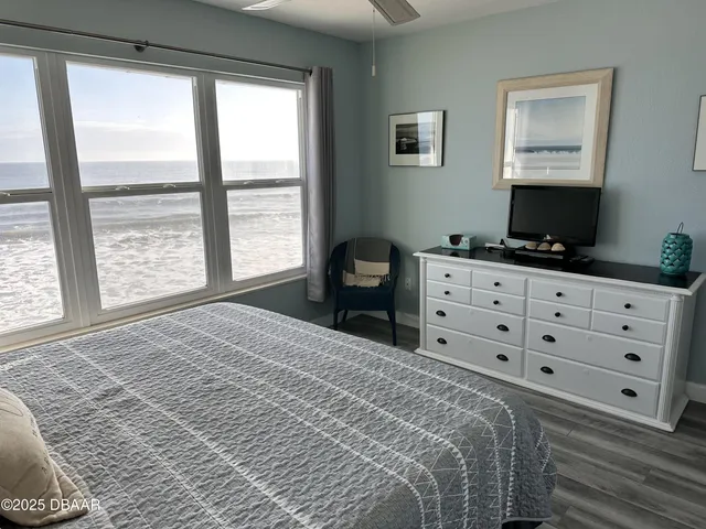 a bedroom with a bed and a flat tv screen on the dresser