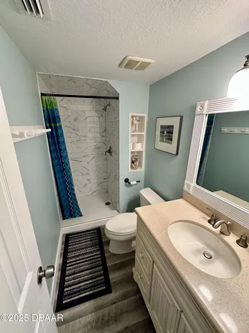 a bathroom with a sink a toilet a mirror and shower