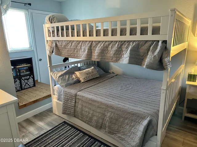 a bedroom with a bed and wooden floor