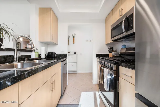 a kitchen with stainless steel appliances granite countertop a stove sink and cabinets