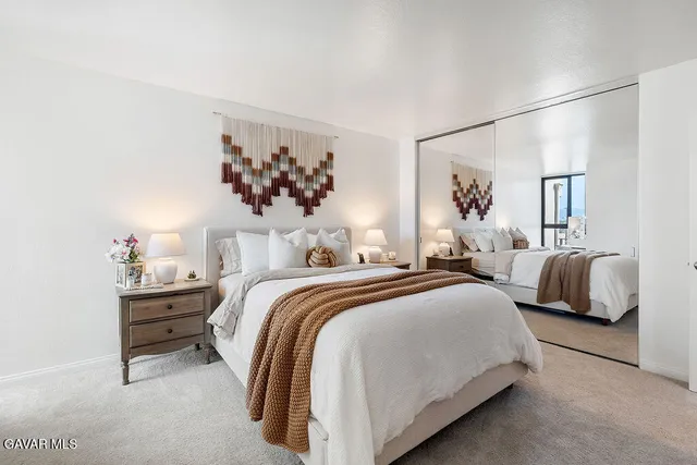 a bedroom with a bed and a painting on the wall