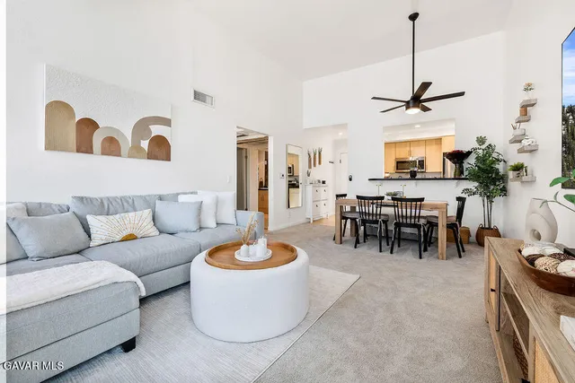 a living room with furniture a dining table and a chandelier