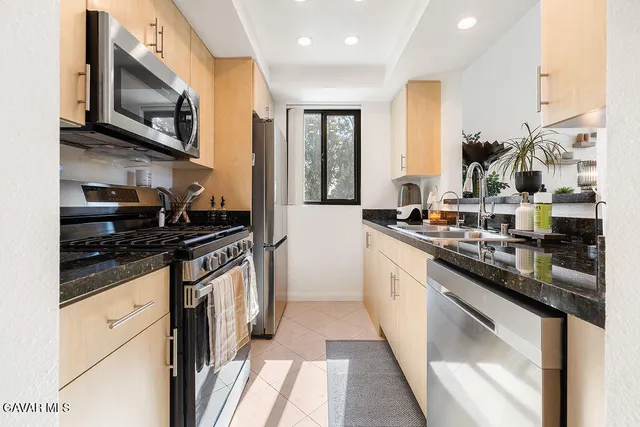 a kitchen with stainless steel appliances granite countertop a stove and a sink