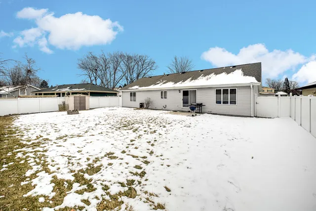 a view of a white house with a yard covered in snow
