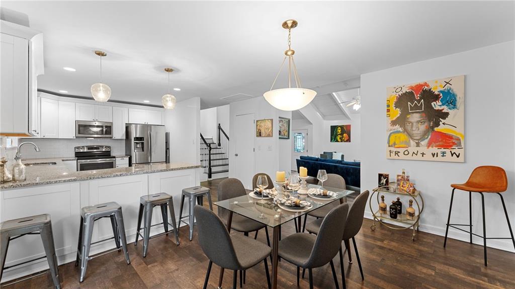 495 Ramsdale Drive Roswell, GA 30075 - Photo 9 of 32 a kitchen with stainless steel appliances kitchen island granite countertop a dining table chairs and a refrigerator a sink with wooden floor