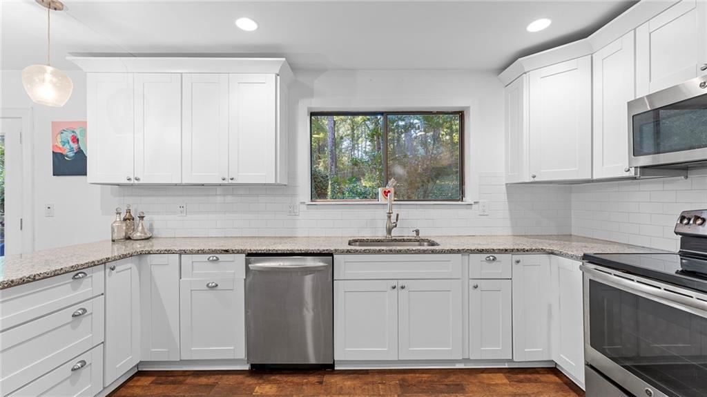 495 Ramsdale Drive Roswell, GA 30075 - Photo 10 of 32 a kitchen with stainless steel appliances granite countertop a sink a stove and cabinets