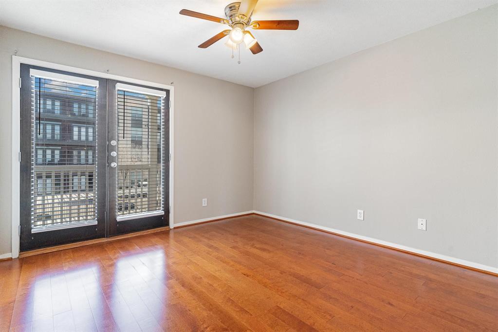 5934 Sandhurst Lane, Unit 207 Dallas, TX 75206 - Photo 12 of 31 Empty room featuring wood finished floors and a ceiling fan