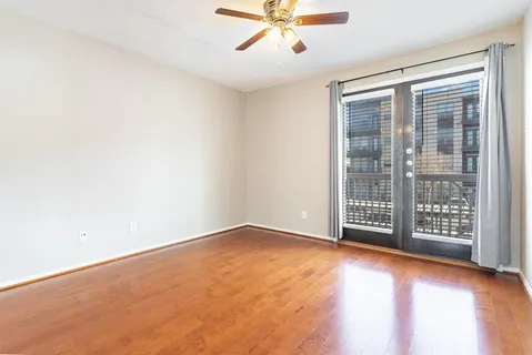 an empty room with windows and view of wooden floor