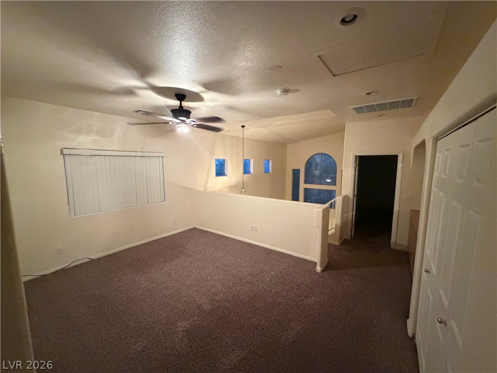 7629 Rory Court Las Vegas, NV 89129 - Photo 14 of 25 An inviting open loft space features vaulted ceilings and plush carpet, ideal for relaxation or a home office.