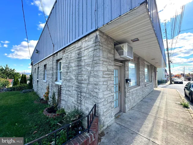 a backyard of a house with plants and wooden fence