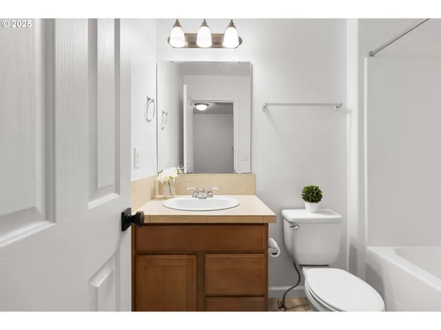 a bathroom with a sink a toilet a mirror and vanity