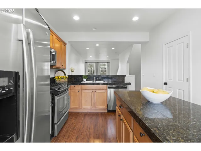 a kitchen with refrigerator and wooden cabinets