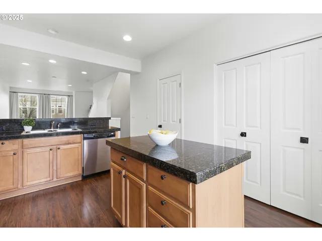 a kitchen with granite countertop a sink cabinets and wooden floor