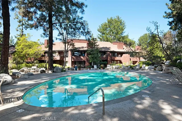 a front view of a house with swimming pool and chairs
