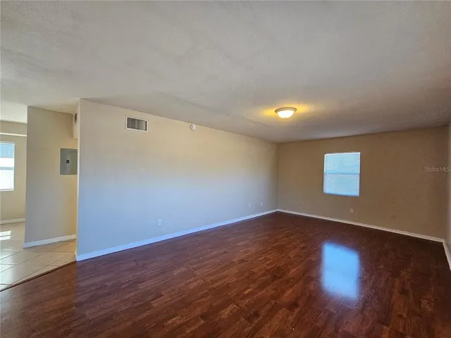 a view of an empty room with wooden floor