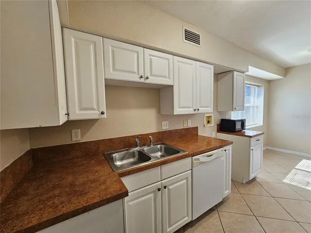 a kitchen with granite countertop white cabinets and sink