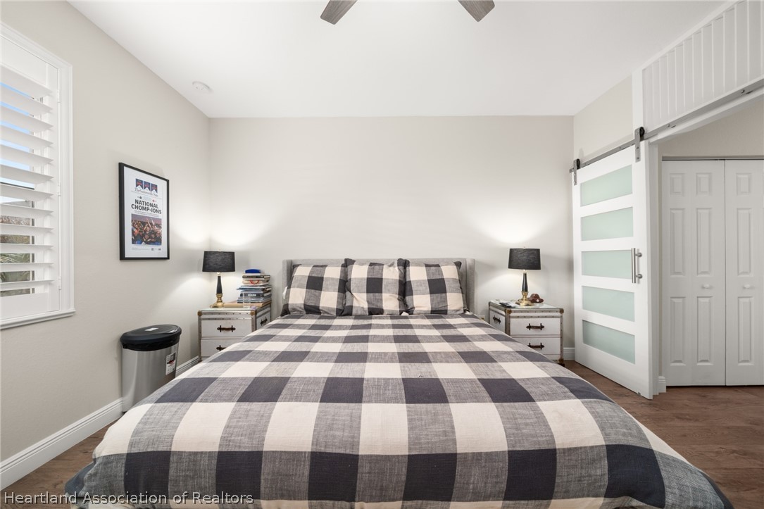 4734 Haw Branch Road, Unit 110 Sebring, FL 33875 - Photo 19 of 50 a bedroom with a bed and wooden floor