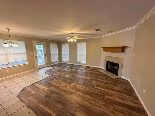a view of an empty room with window and fire place