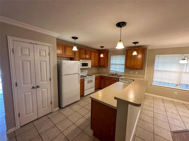 a kitchen with granite countertop a refrigerator and a sink