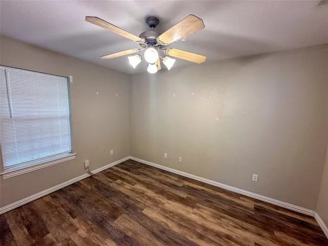 an empty room with a window and a fan