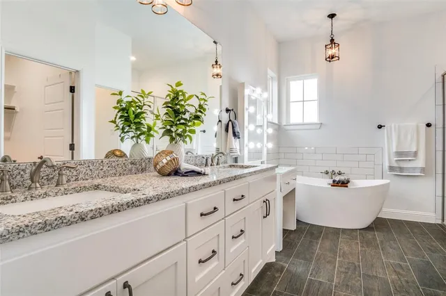 a bathroom with a sink a bathtub a mirror and vanity