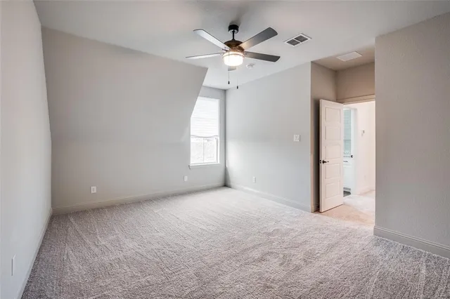 an empty room with a ceiling fan and a window