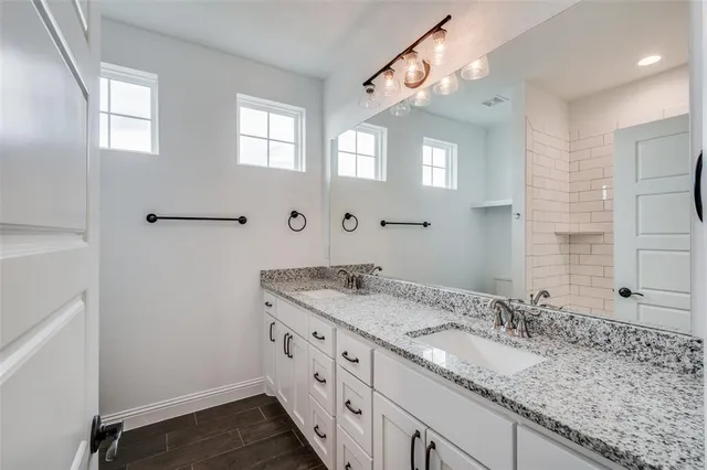 a bathroom with a granite countertop sink and a mirror