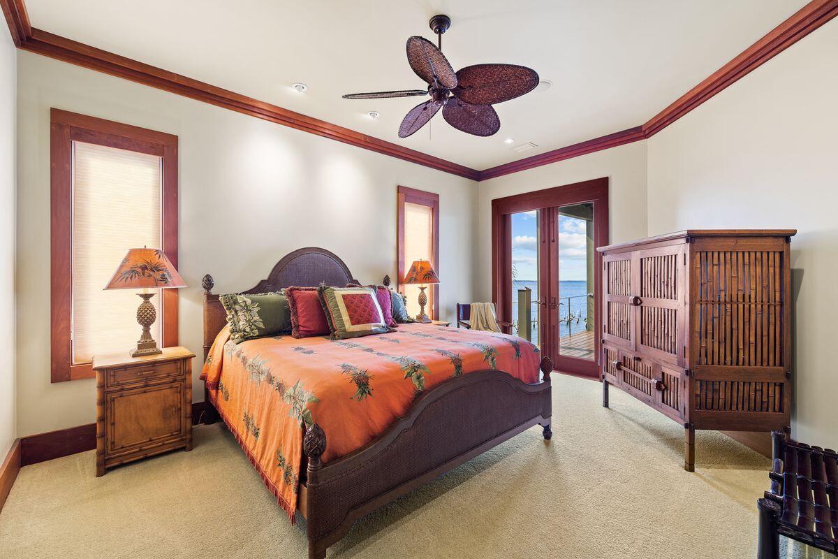 281 Grove Lane Freeport, FL 32439 - Photo 29 of 36 a bedroom with a large bed and a chandelier