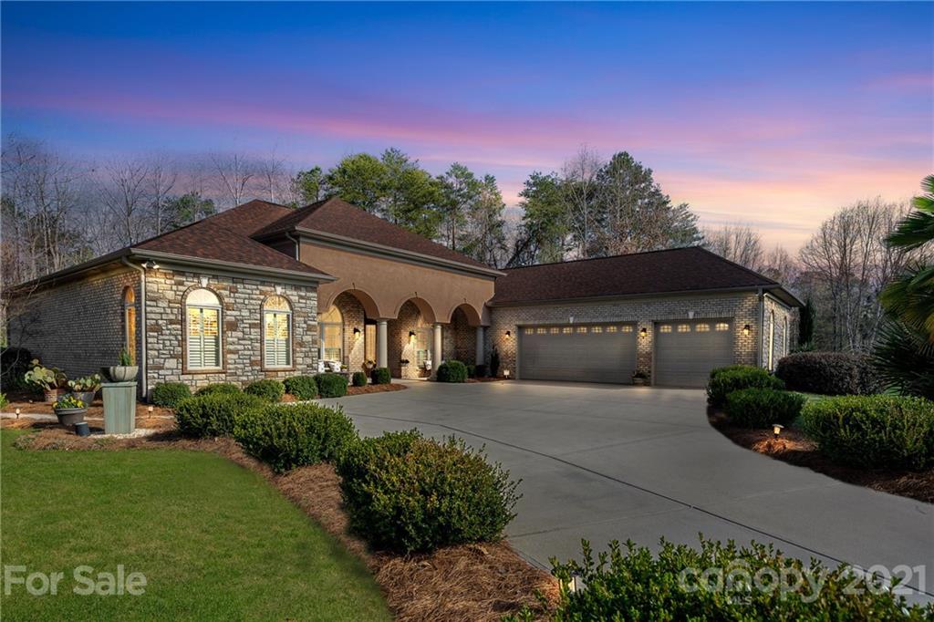 a front view of a house with a yard and mountain view