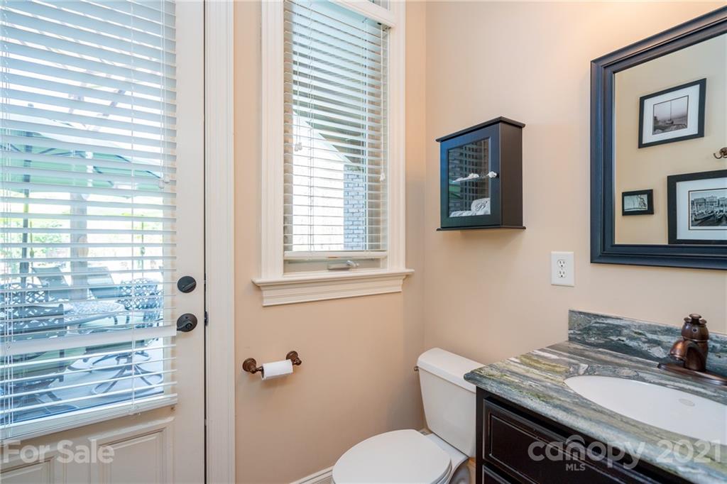 2341 Valelake Road York, SC 29745 - Photo 34 of 48 a bathroom with a granite countertop toilet a sink a mirror and a window