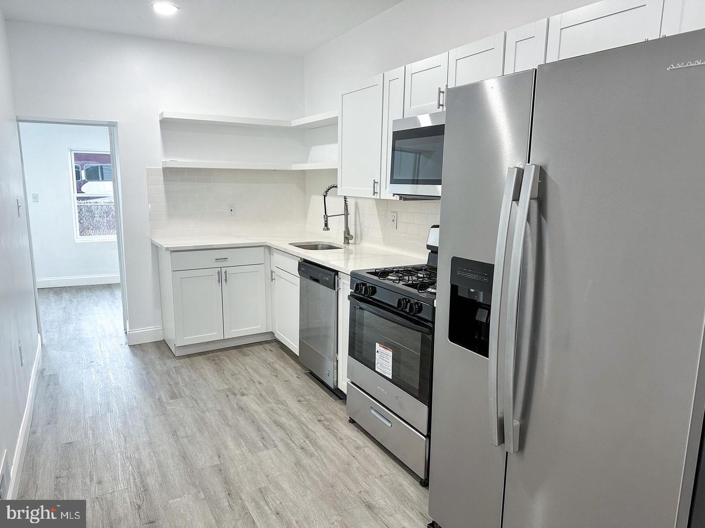 255 3rd Street Gloucester City, NJ 08030 - Photo 29 of 35 a kitchen with stainless steel appliances a stove a refrigerator and a sink
