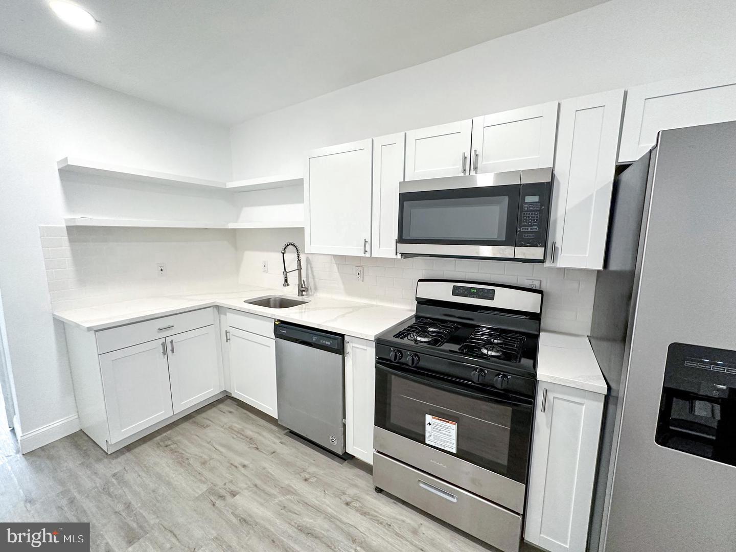 255 3rd Street Gloucester City, NJ 08030 - Photo 30 of 35 a kitchen with sink a microwave and cabinets