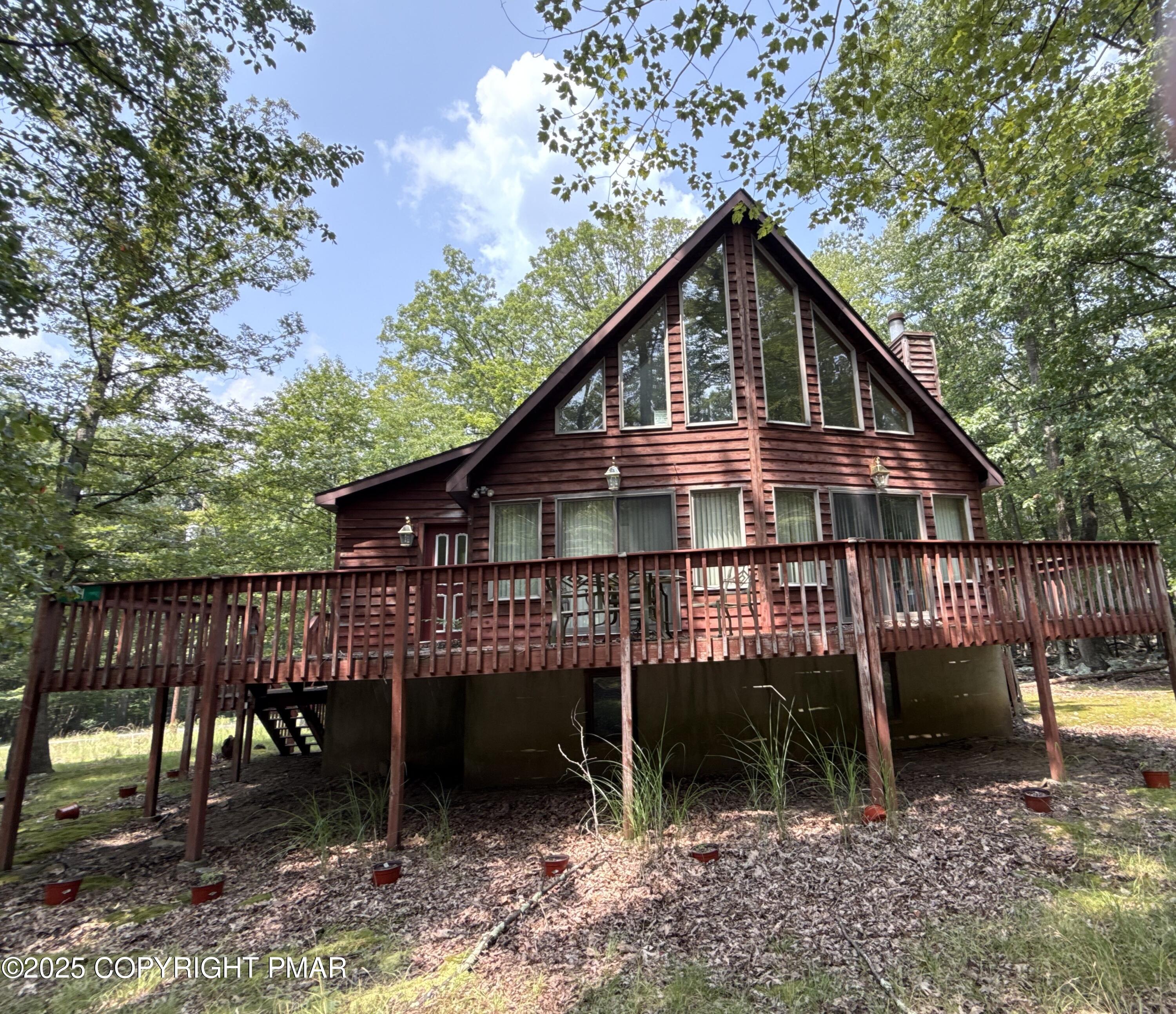 a view of a house with a yard chairs and wooden fence