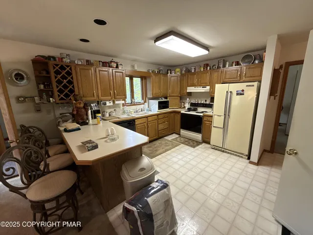 a kitchen with a sink a stove a refrigerator and cabinets