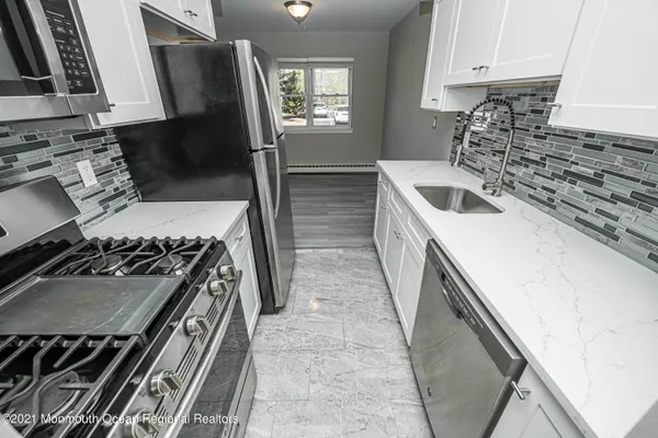 a kitchen with a sink stove top oven and cabinets