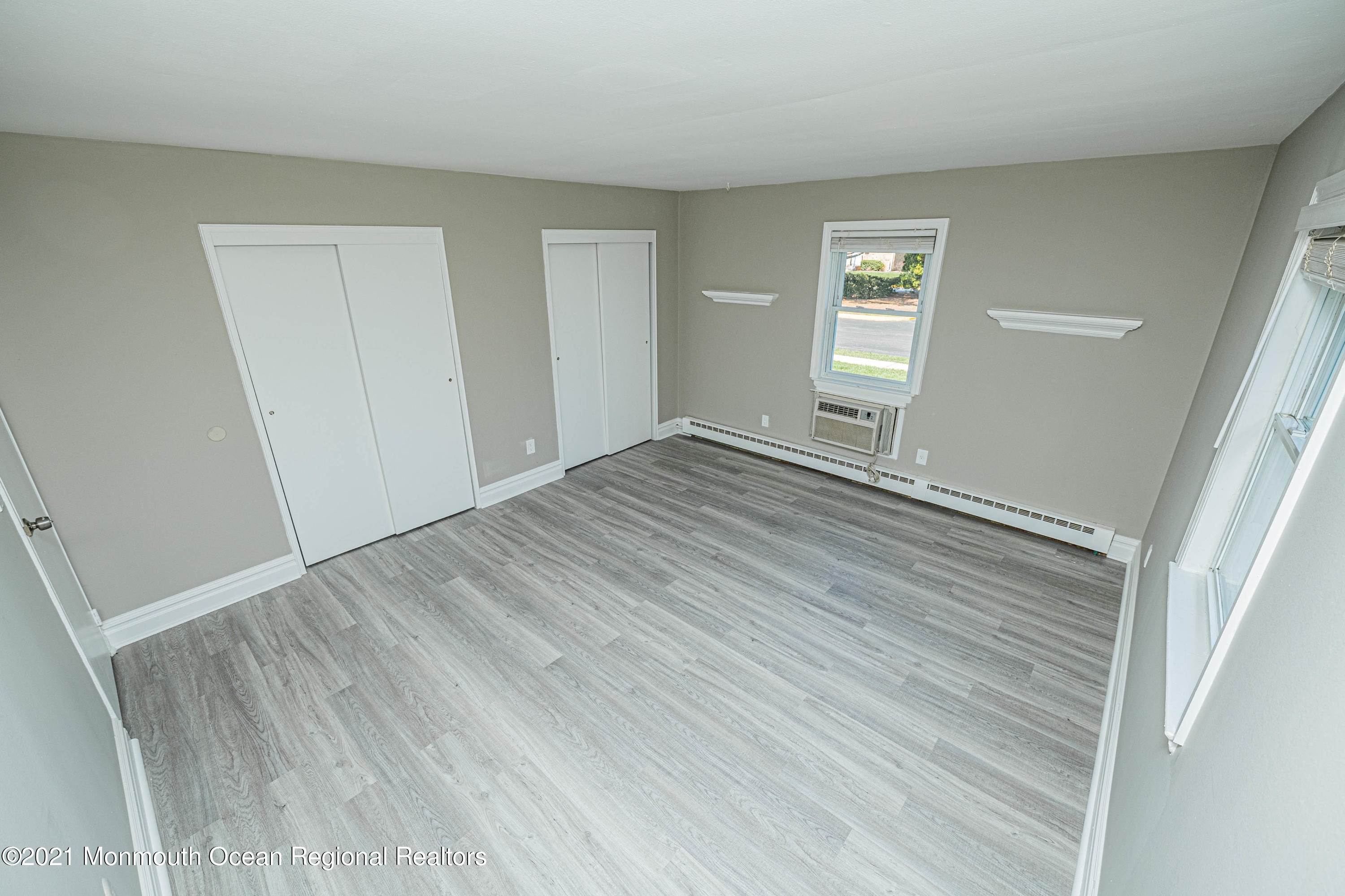 59 Stonehurst Boulevard, Unit B Freehold, NJ 07728 - Photo 17 of 25 a view of an empty room with wooden floor and a window